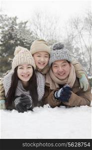 Family laying in snow for portrait