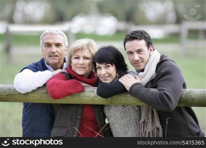 Family leaning against fence