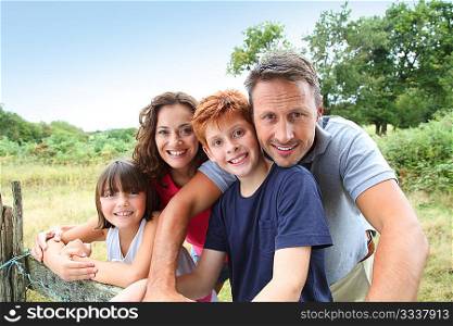 Family leaning on a fence