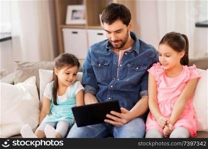 family, leisure and people concept - happy father and daughters with tablet pc computer at home. happy father and daughters with tablet pc at home