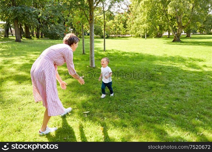 family, leisure and people concept - happy mother and little son having fun at summer park. happy mother and son having fun at summer park