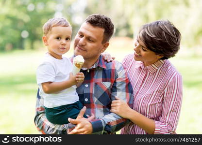 family, leisure and people concept - happy mother, father and little son eating ice cream at summer park. happy family at summer park