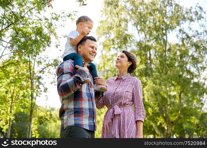 family, leisure and people concept - happy mother, father and little son having fun at summer park. happy family having fun at summer park