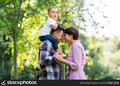 family, leisure and people concept - happy mother, father and little son at summer park. happy family at summer park