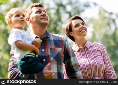 family, leisure and people concept - happy mother, father and little son at summer park. happy family at summer park