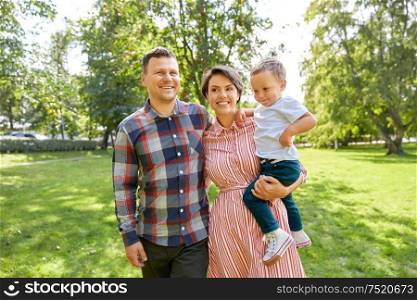 family, leisure and people concept - happy mother, father and little son at summer park. happy family at summer park