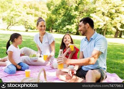 family, leisure and people concept - happy mother, father and two daughters having picnic at summer park. happy family having picnic at summer park