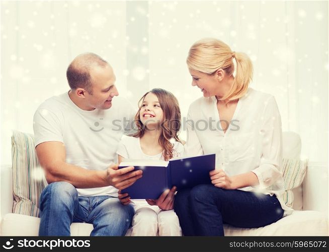 family, leisure, education and people - smiling mother, father and little girl reading book over snowflakes background