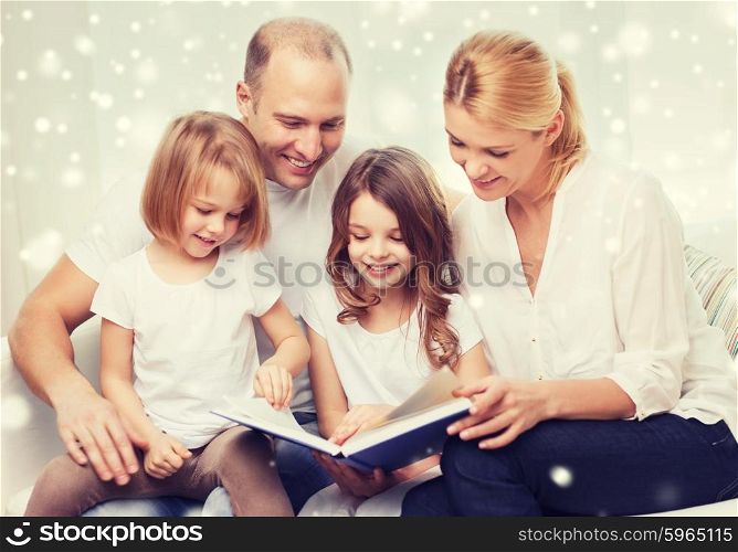 family, leisure, education and people - smiling mother, father and little girls reading book over snowflakes background