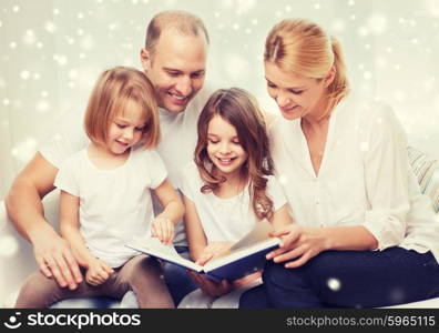 family, leisure, education and people - smiling mother, father and little girls reading book over snowflakes background