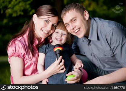 Family Lifestyle Portrait Of A Mum And Dad With Their Kid Having Fun Outdoors