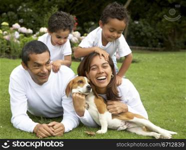 family lifestyle portrait of a mum and dad with their two kids and their dog having fun outdoors