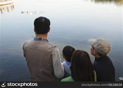 Family looking at ducks in a lake