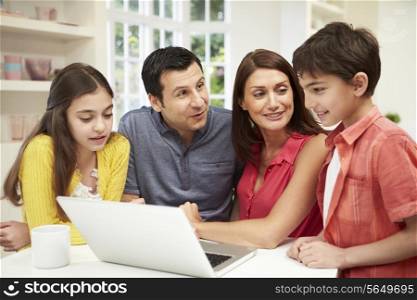 Family Looking at Laptop Over Breakfast