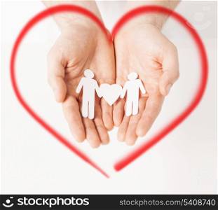 family, love and happiness concept - mans hands showing two paper men with heart shape