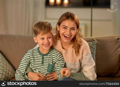 family, love and people concept - happy laughing mother with her little son in evening. happy laughing mother with her son at home