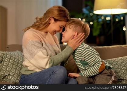 family, love and people concept - happy smiling mother and son at home in evening. happy smiling mother and son at home