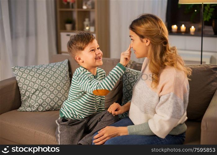 family, love and people concept - happy smiling mother touching her little son&rsquo;s nose at home in evening. happy mother touching little son&rsquo;s nose at home