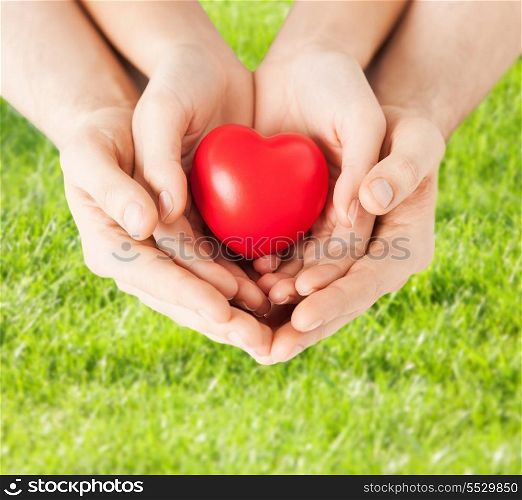 family, love and relationships concept - closeup of woman and man hands with heart