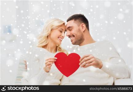 family, love, valentines day and people concept - happy couple with red heart hugging on sofa at home