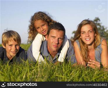 Family lying in a field