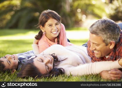 Family Lying On Grass In Countryside