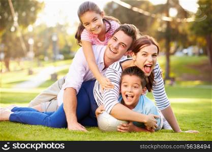 Family Lying On Grass In Park Together
