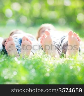 Family lying on green grass in spring park