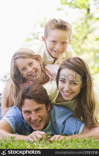 Family lying outdoors smiling