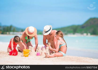 Family making sand castle at tropical beach together. Family making sand castle at tropical white beach