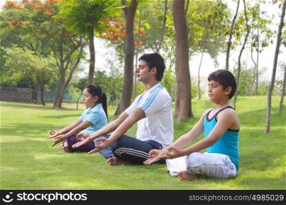 Family meditating outdoors