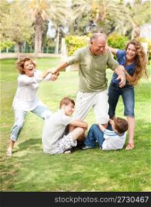 Family members holding back grandfather and having fun