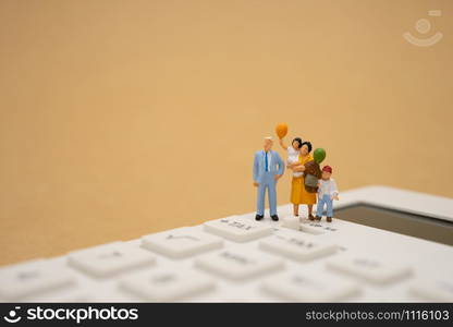 Family Miniature people Pay queue Annual income (TAX) for the year on calculator. using as background business concept and finance concept with copy space for your text or design.