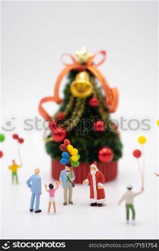 Family Miniature people standing on Christmas tree Celebrate Christmas on December 25 every year. using as background xmas concept with copy spaces for you