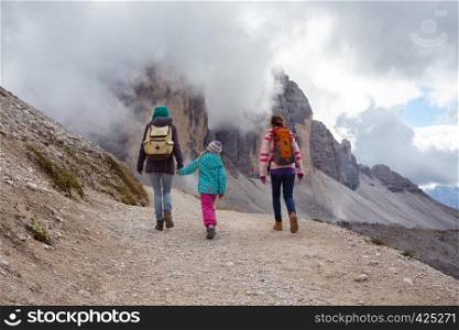 family - mother and two daughters girls sisters hikers at the mountains Dolomites, Italy. Tre Cime di Lavaredo