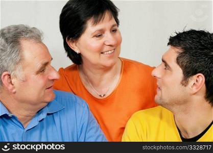 Family - mother, father, and adult son looking at each other