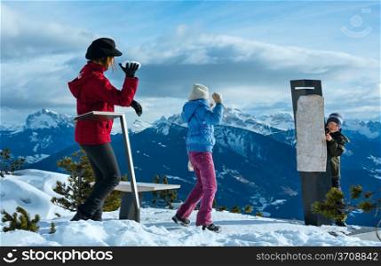 Family (mother with two children) plays at snowballs on winter mountain slope ( Rittner Horn, Italy)