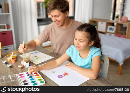 family, motherhood and leisure concept - happy smiling father spending time with his little daughter and drawing with colors at home. happy father with little daughter drawing at home