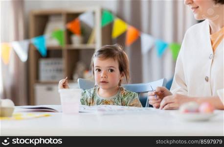 family, motherhood and leisure concept - mother spending time with her little daughter and drawing at home. mother with little daughter drawing at home