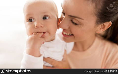 family, motherhood and people concept - close up of happy mother with little baby boy at home. happy mother with little baby boy at home