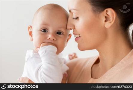 family, motherhood and people concept - close up of happy mother with little baby boy at home. happy mother with little baby boy at home