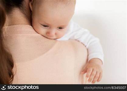 family, motherhood and people concept - close up of little baby boy with mother. close up of little baby boy with mother