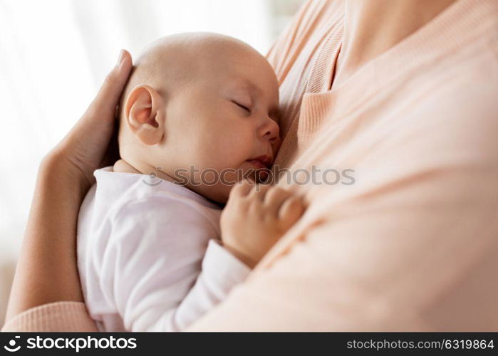 family, motherhood and people concept - close up of mother holding sleeping little baby boy. close up of mother holding sleeping baby