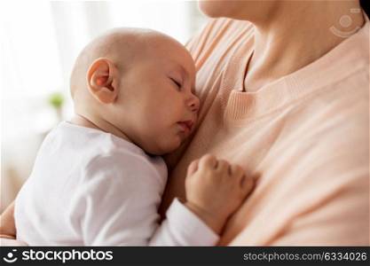family, motherhood and people concept - close up of mother holding sleeping little baby boy. close up of mother holding sleeping baby