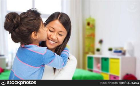 family, motherhood and people concept - happy mother and daughter hugging and kissing over kids room at home background. happy mother and daughter hugging and kissing. happy mother and daughter hugging and kissing