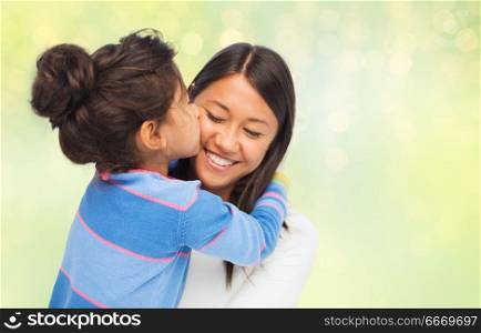 family, motherhood and people concept - happy mother and daughter hugging and kissing over green holidays lights background. happy mother and daughter hugging and kissing. happy mother and daughter hugging and kissing