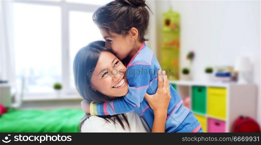 family, motherhood and people concept - happy mother and daughter hugging and kissing over kids room at home background. happy mother and daughter hugging and kissing. happy mother and daughter hugging and kissing