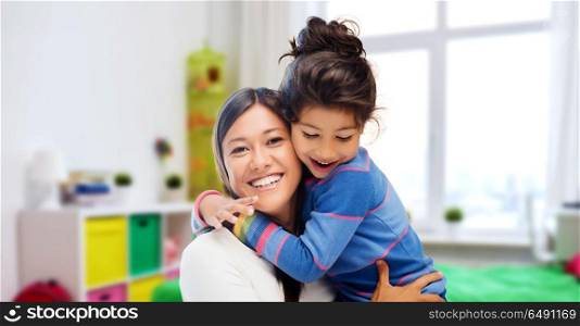 family, motherhood and people concept - happy mother and daughter hugging over over kids room at home background. happy mother and daughter hugging at home. happy mother and daughter hugging at home