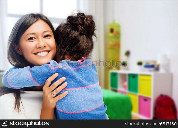 family, motherhood and people concept - happy mother and daughter hugging over over kids room at home background. happy mother and daughter hugging at home. happy mother and daughter hugging at home