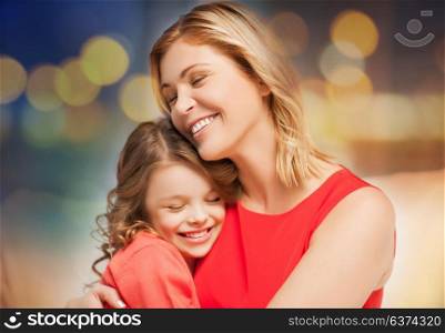 family, motherhood and people concept - happy mother and daughter hugging over festive lights background. happy mother and daughter hugging